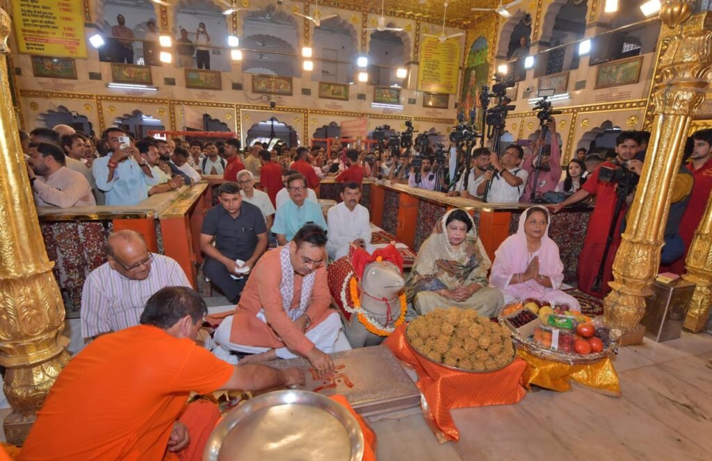 प्रधानमंत्री नरेंद्र मोदी की दीर्घायु के लिए मोती डूंगरी मंदिर में पूजा के बाद श्रद्धालुओं को प्रसाद बांटते सीएम